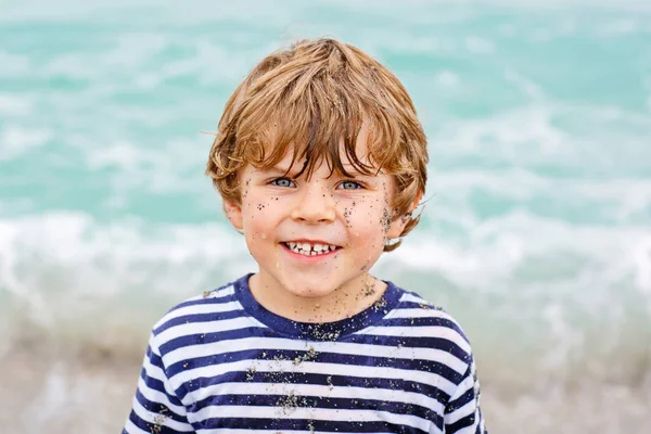 Liten unge pojke kör på stranden av oceanen — Stockfoto