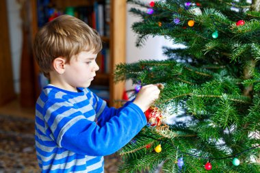 Sevimli küçük çocuk çocuk renkli topları ile Noel ağacı süsleme