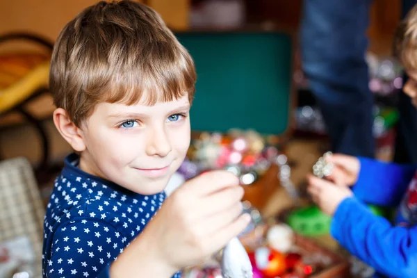 Mignon petit garçon décorant arbre de Noël avec boule colorée — Photo