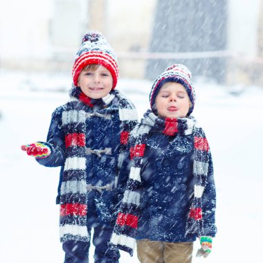 Mutlu çocuklar kışın karla eğleniyor.