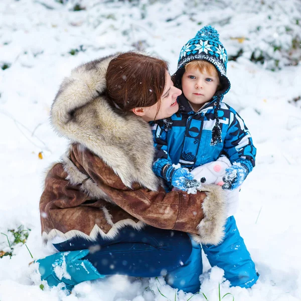 Glückliches Kind und Mutter, die im Winter Spaß mit Schnee haben — Stockfoto