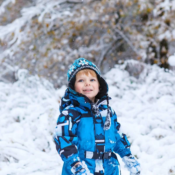 Niño feliz divirtiéndose con nieve en invierno — Foto de Stock