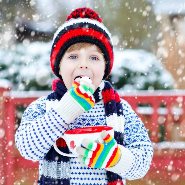 Schattige jongen houden grote cup en warme chocolade drinken en marshmallo — Stockfoto