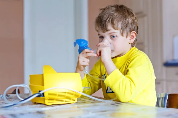 Χαριτωμένο παιδί αγόρι κάνοντας θεραπεία εισπνοής από τη μάσκα της συσκευής εισπνοής — Φωτογραφία Αρχείου