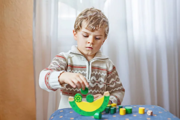 Мальчик играет с деревянной игрушкой дома — стоковое фото