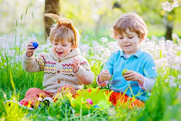 Két kisfiú barát húsvéti nyuszifülekben tojásvadászat közben — Stock Fotó
