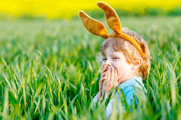 Menino pequeno se divertindo com a tradicional caça ao ovo de Páscoa — Fotografia de Stock