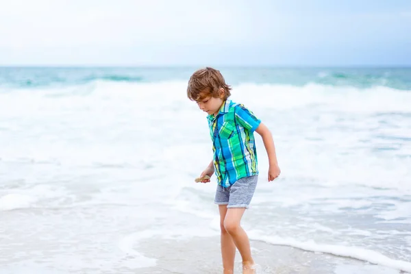 Menino pequeno que corre na praia do oceano — Fotografia de Stock