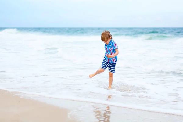 Little kid boy running on the beach of ocean — Stock Photo, Image