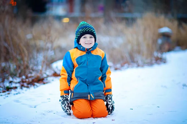 Gelukkig kid jongen hebben plezier met sneeuw in de winter — Stockfoto