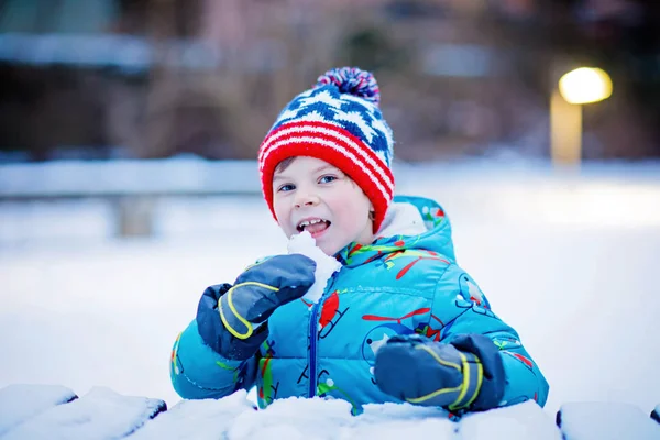 Happy kid boy having fun with snow in winter — Stock Photo, Image