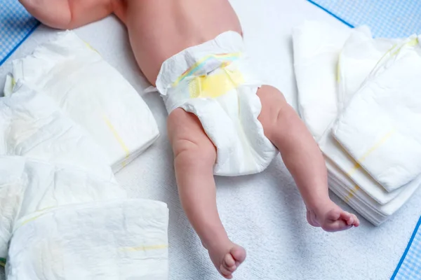 Pés de bebê recém-nascido na mesa de troca com fraldas — Fotografia de Stock