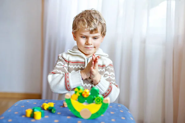 Dítě chlapec hraje s dřevěnými rovnováhu hračky doma — Stock fotografie