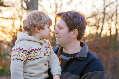 Baba ve küçük park veya orman, açık havada.