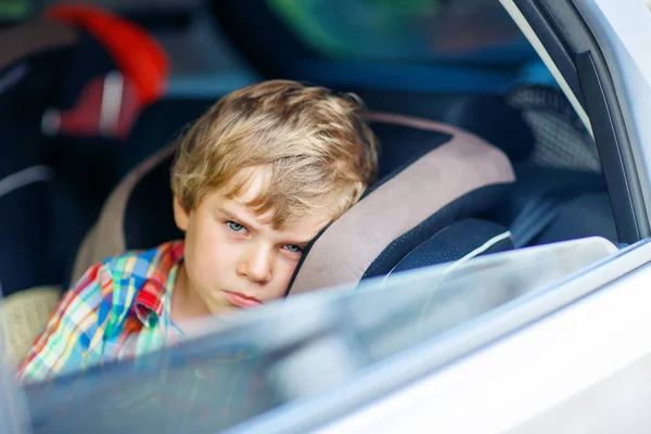 Sad tired kid boy sitting in car  during traffic jam — Stock Photo, Image