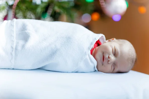 Bebé recién nacido de una semana envuelto en manta cerca del árbol de Navidad — Foto de Stock