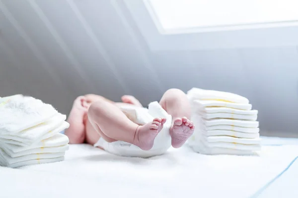 Pés de bebê recém-nascido na mesa de troca com fraldas — Fotografia de Stock