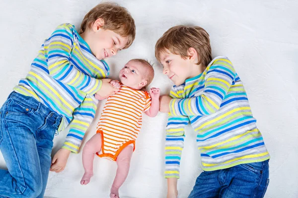 Dois pequenos meninos pré-escolares felizes com bebê recém-nascido menina — Fotografia de Stock