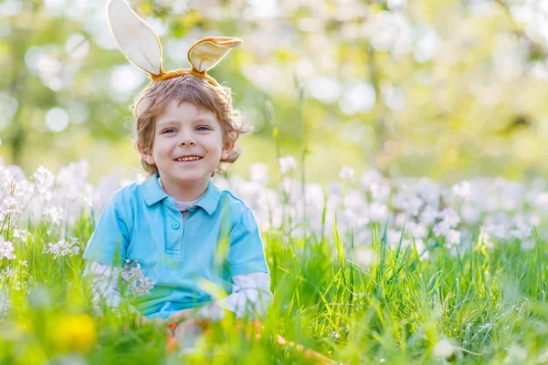 Niño pequeño con orejas de conejo de Pascua en primavera — Foto de Stock