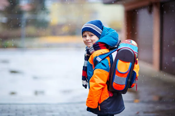 Menino feliz se divertindo com neve a caminho da escola — Fotografia de Stock