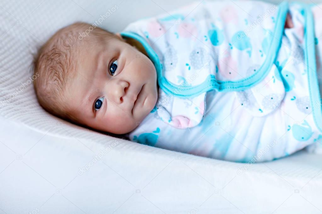 Cute little newborn baby girl wrapped in blanket
