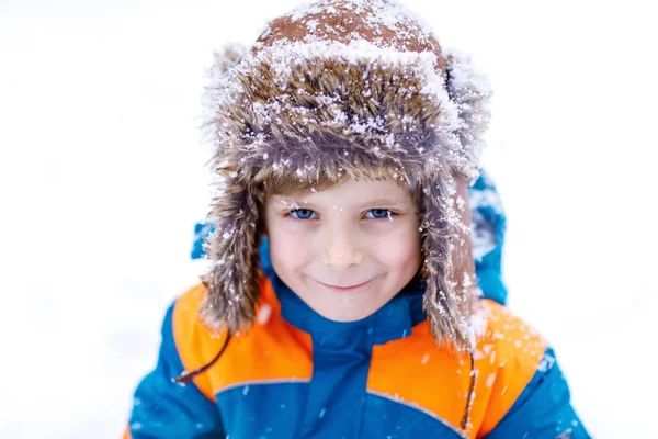 Menino feliz se divertindo com neve no inverno — Fotografia de Stock