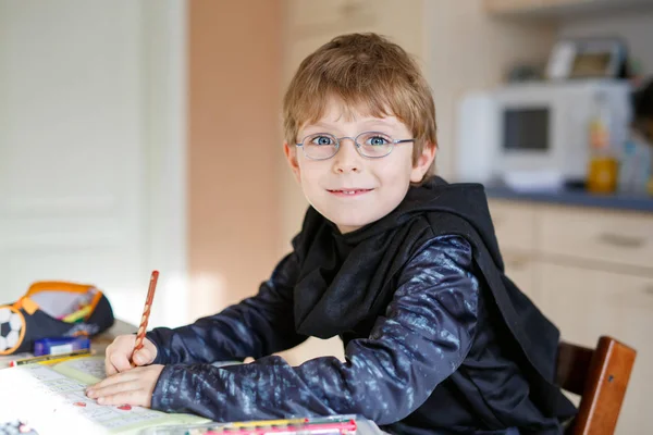 Menino da escola feliz em casa fazendo lição de casa — Fotografia de Stock