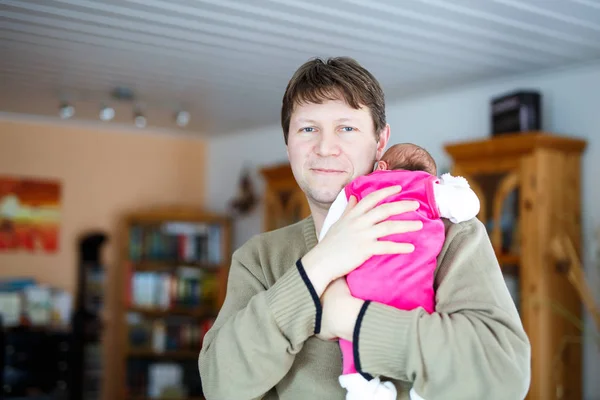 Ευτυχισμένος περήφανος νεαρός πατέρας κρατώντας την κόρη του νεογέννητο μωρό στον ύπνο — Φωτογραφία Αρχείου