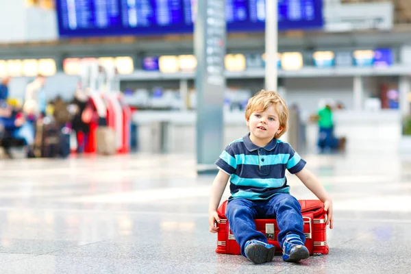 空港でスーツケースを持って休暇旅行に行く子供男の子 — ストック写真