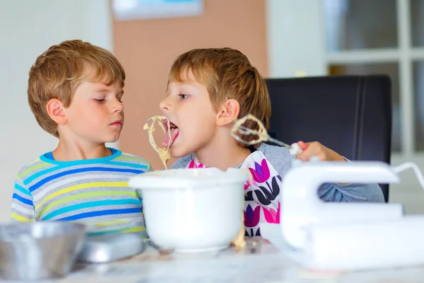 Два мальчика пекут торт на кухне. — стоковое фото