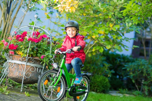 Little preschool kid boy in helmet biking on bicycle in the autu — Stock Photo, Image