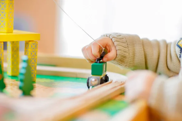 Menino criança brincando com brinquedo de madeira, dentro de casa — Fotografia de Stock