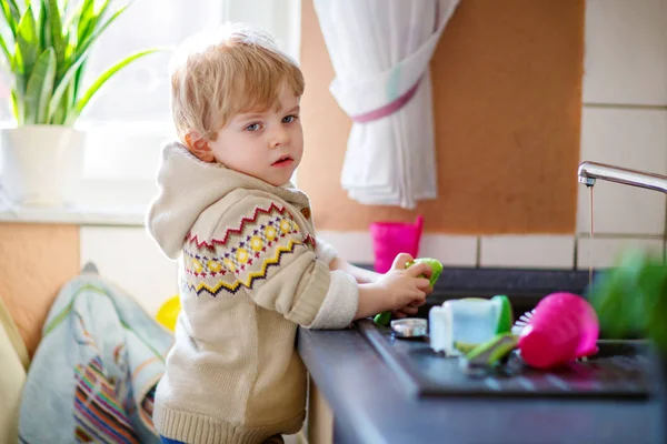 Pequeño niño ayudando en la cocina con lavar los platos — Foto de Stock