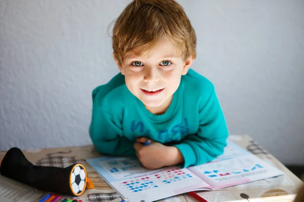 Szczęśliwy chłopiec ze szkoły w domu robi pracę domową — Zdjęcie stockowe