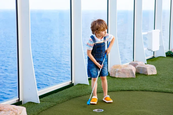 Маленький хлопчик грає в міні-гольф на круїзному лайнері . — стокове фото