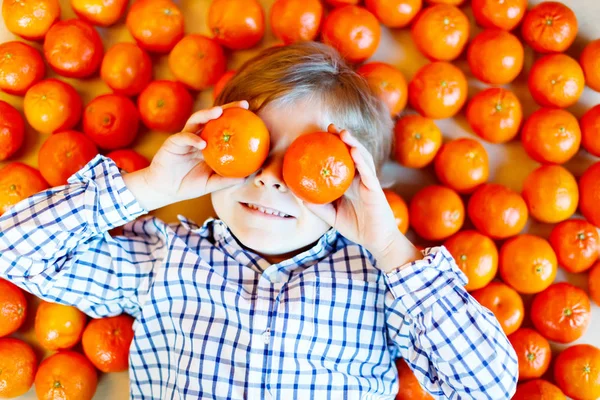 Dítě chlapec s mandarinky zdravé ovoce — Stock fotografie