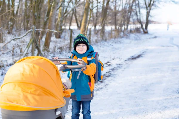 Orgulloso niño pequeño empujando cochecito con bebé recién nacido . — Foto de Stock