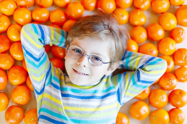 Dítě chlapec s mandarinky zdravé ovoce — Stock fotografie