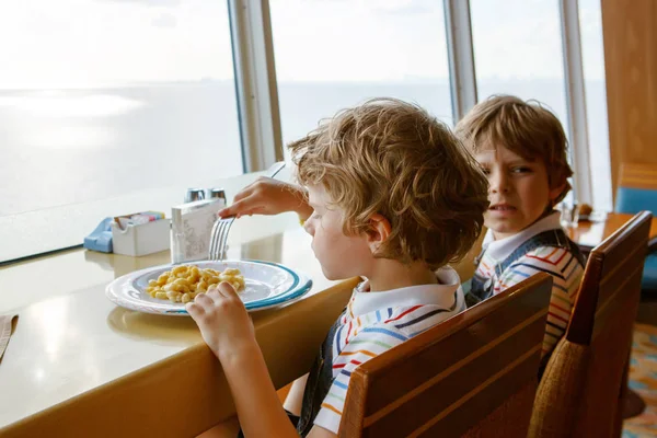 Dwóch chłopców w wieku przedszkolnym dzieci zjada makaronu siedział w stołówce szkolnej — Zdjęcie stockowe