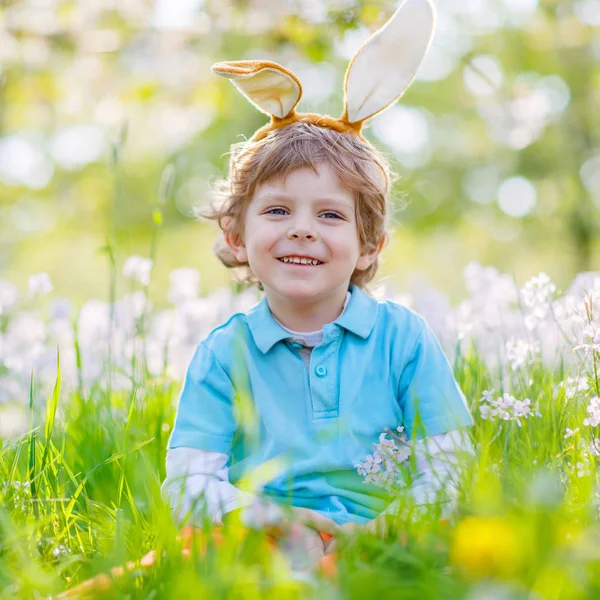 Niño pequeño con orejas de conejo de Pascua en primavera — Foto de Stock