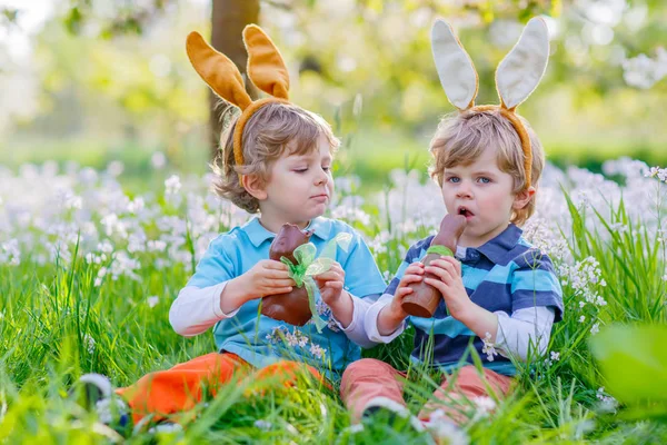 Dvě malé děti si hrají s Velikonoční čokoládové bunny — Stock fotografie