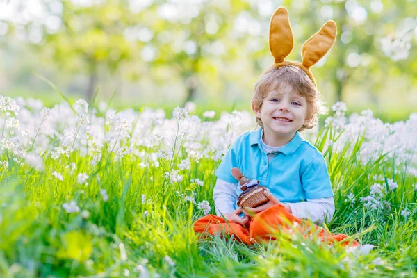 Liten unge pojke med Easter bunny öron och cupcake — Stockfoto