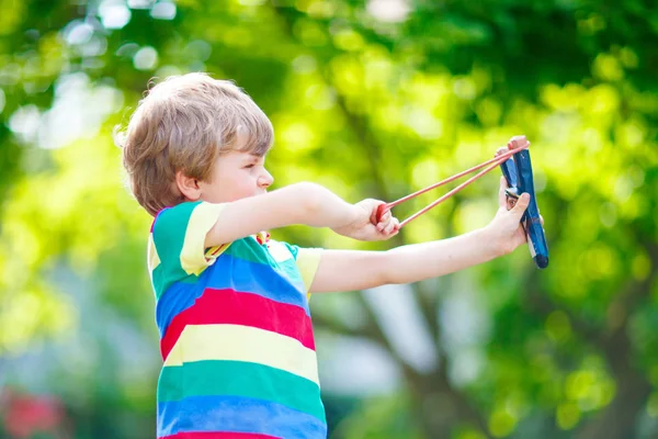 Kleiner Junge schießt auf Holzschleuder — Stockfoto