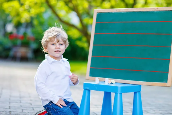 Malý chlapec u tabule, procvičování matematiky — Stock fotografie