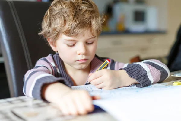 Menino da escola feliz em casa fazendo lição de casa — Fotografia de Stock
