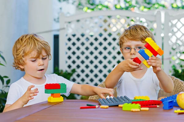 Two little kid boys playing with plastic blocks together — Stock Photo, Image