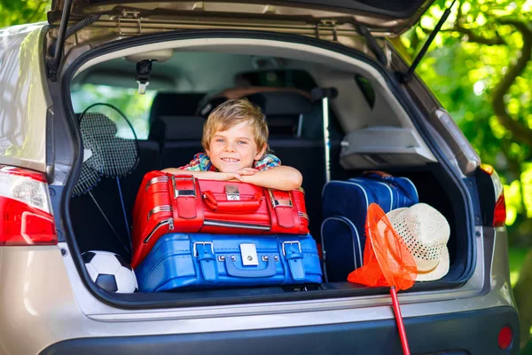 Pequeño niño sentado en el maletero del coche justo antes de salir para vaca — Foto de Stock