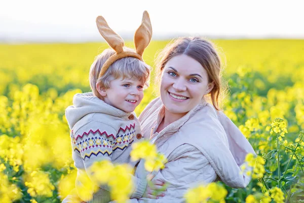 Pieni lapsi ja hänen äitinsä pääsiäispupu korvat ottaa — kuvapankkivalokuva