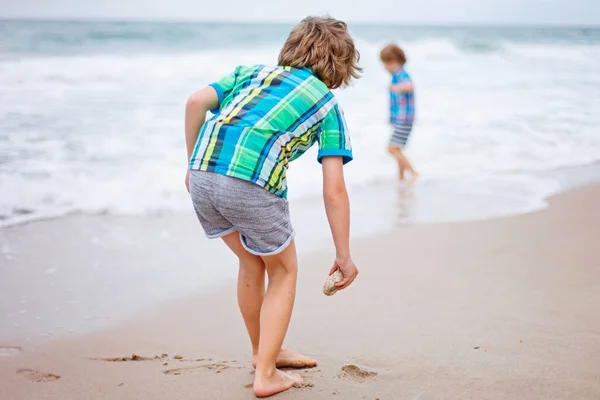 Little kid boy running on the beach of ocean — Stock Photo, Image