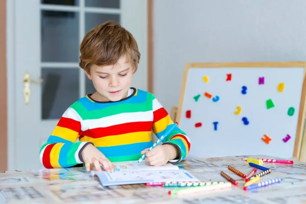 Menino da escola feliz em casa fazendo lição de casa — Fotografia de Stock